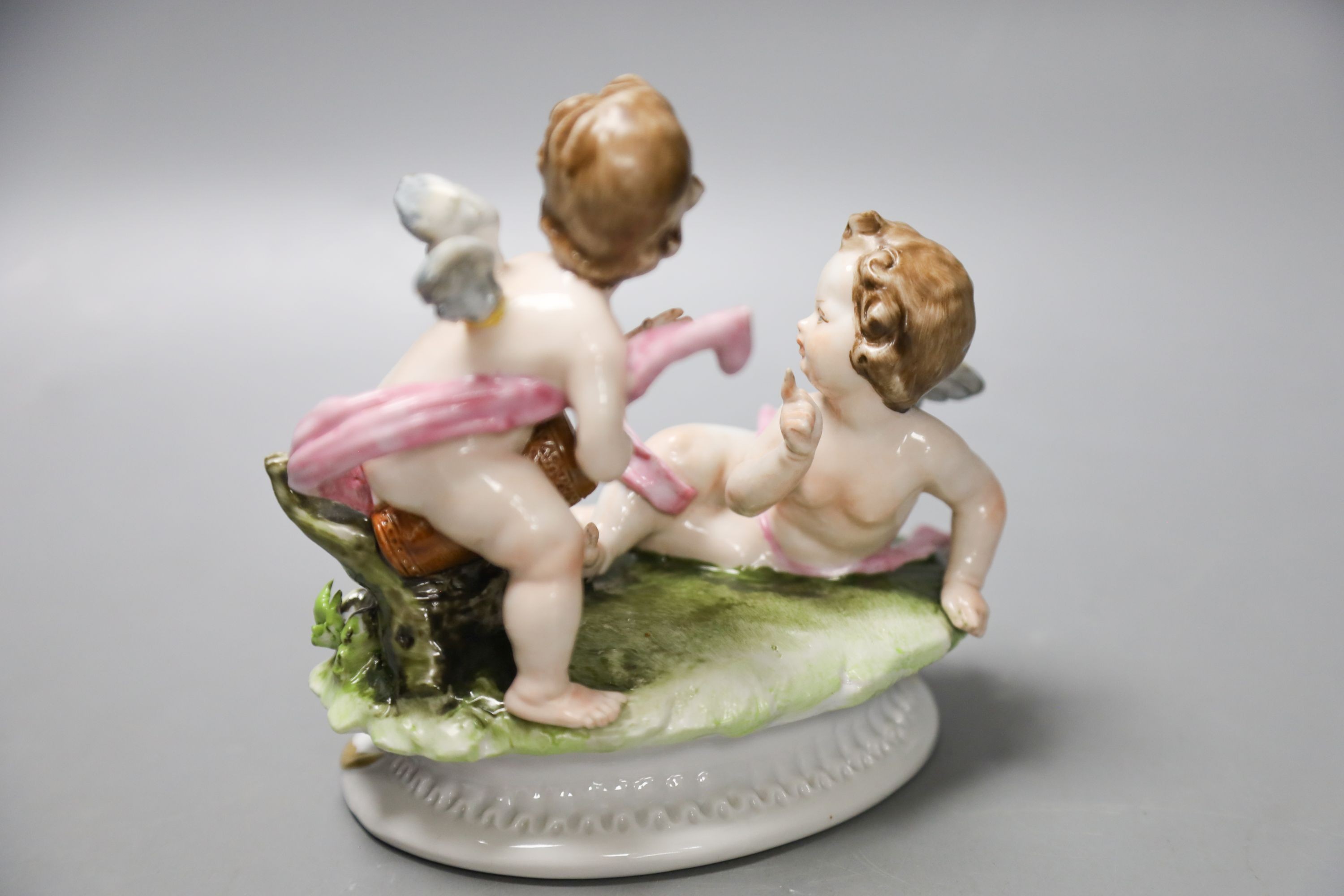 A Luigi Fabris porcelain figure of a lady wearing a crinoline dress, holding baskets of flowers, and two other figural groups (3)